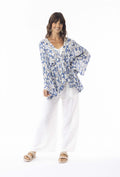 Model showcasing the Valentina Ruched V Top with dramatic sleeves and cinched waist for a stylish look.