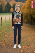 Model wearing Staying Alive V Neck jumper against a fall landscape with a SALE sign, showcasing vibrant style.