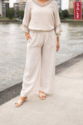 Linen Lace Trim Top styled with wide leg pants by a serene waterfront, perfect for casual elegance.