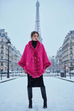 Camilla Shawl in vibrant pink, featuring faux fur trim, worn against a snowy Paris backdrop with the Eiffel Tower.