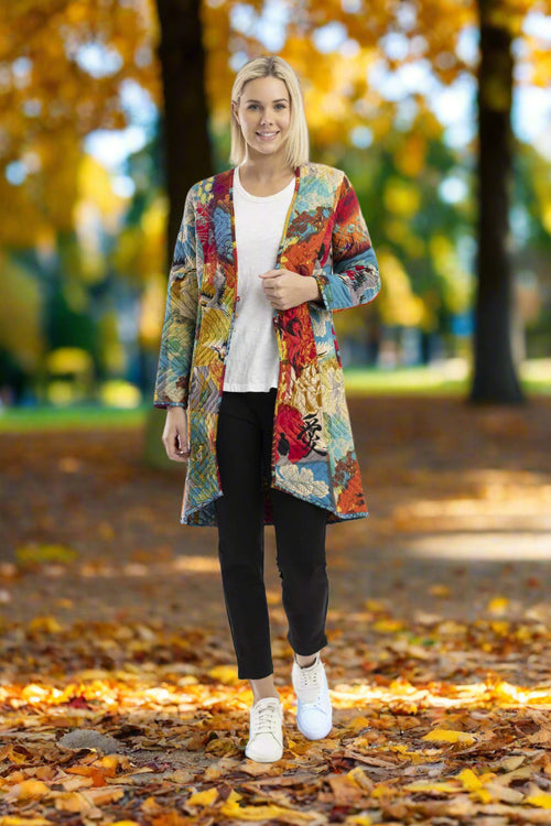 Model wearing the Billie Jean Coat Reversible with colorful prints in a park during autumn.