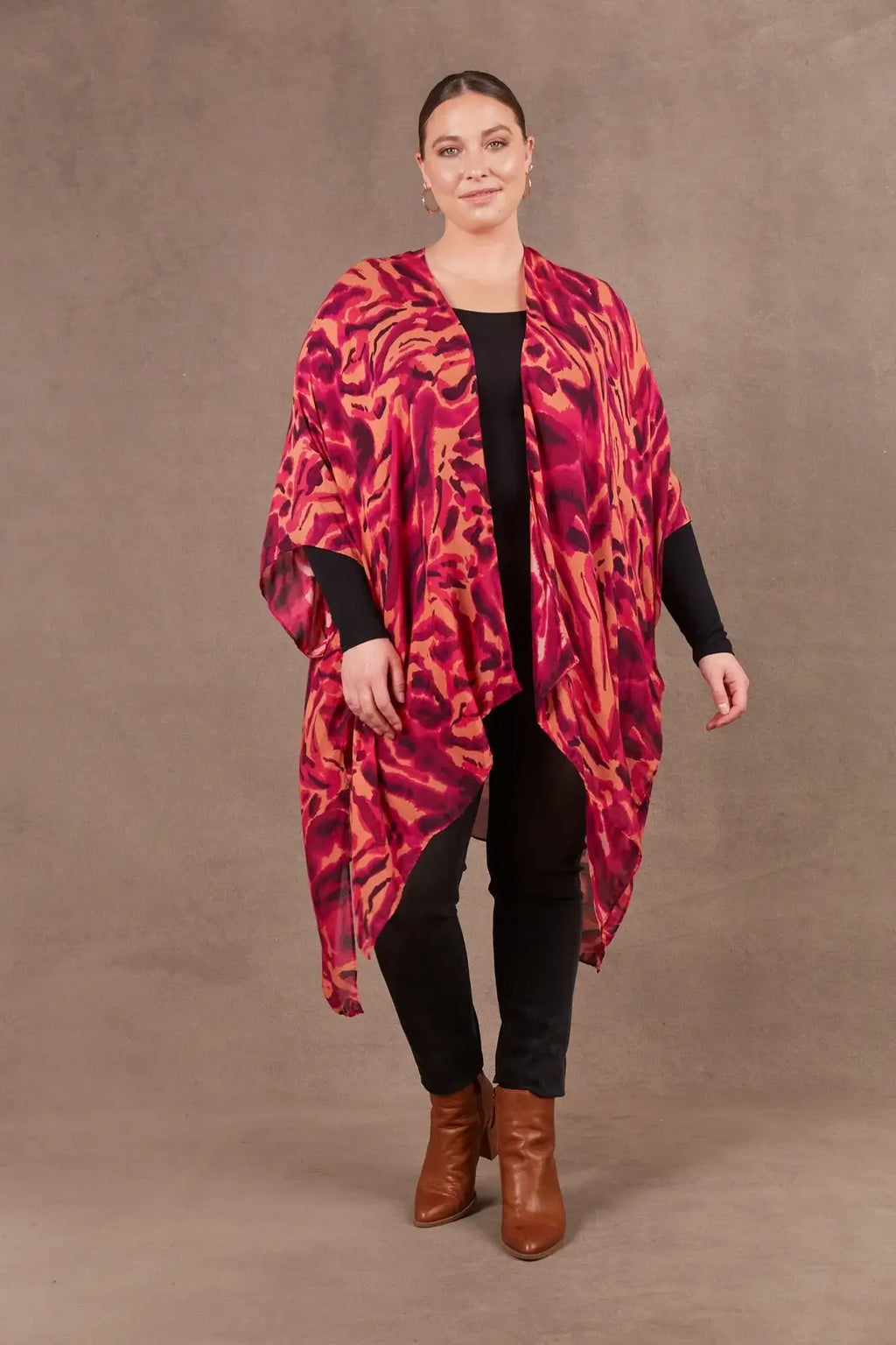 Mayan Cape in vibrant pink and orange design, lightweight with 3/4 sleeves and handkerchief hem, perfect for layering.