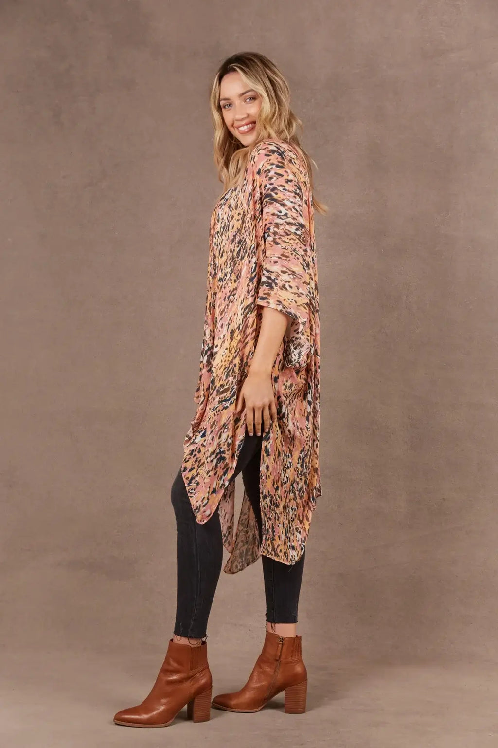 Model wearing a vibrant Mayan Cape with 3/4 length sleeves and handkerchief hem.