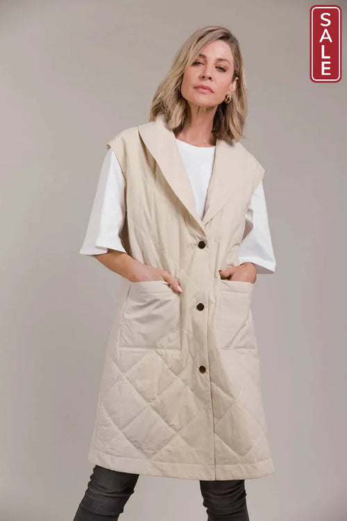 Argo Longline Vest Ecru displayed on a model, showcasing its quilted design and stylish lapel. Perfect for layering!