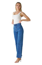 Woman modeling WK 3085 Patch pocket jean with high-rise waist and wide leg silhouette.