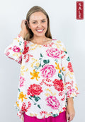 WT 72851L Frill hem top featuring a bright floral design and ruffled hem, perfect for spring style.