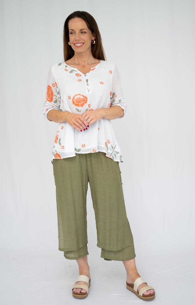 Model wearing QQ Julia Layered Top with floral design, paired with green pants, showcasing effortless style.