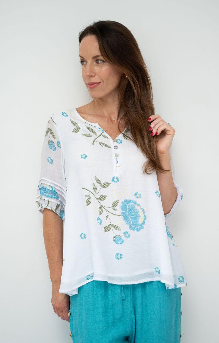 Woman wearing QQ Julia Layered Top with floral design, featuring relaxed fit and button front details.
