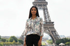 WT Suzy Eiffel tower Shirt model stands in front of the Eiffel Tower, showcasing its chic and stylish design.