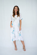 WT Panel dress 38592DM in teal and green floral pattern, short sleeve with pockets, showcased on a model.