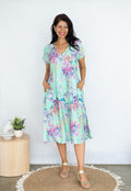 Joleen Dress featuring V neck, short sleeves, pockets, and a beautiful aqua with spring blossoms design.
