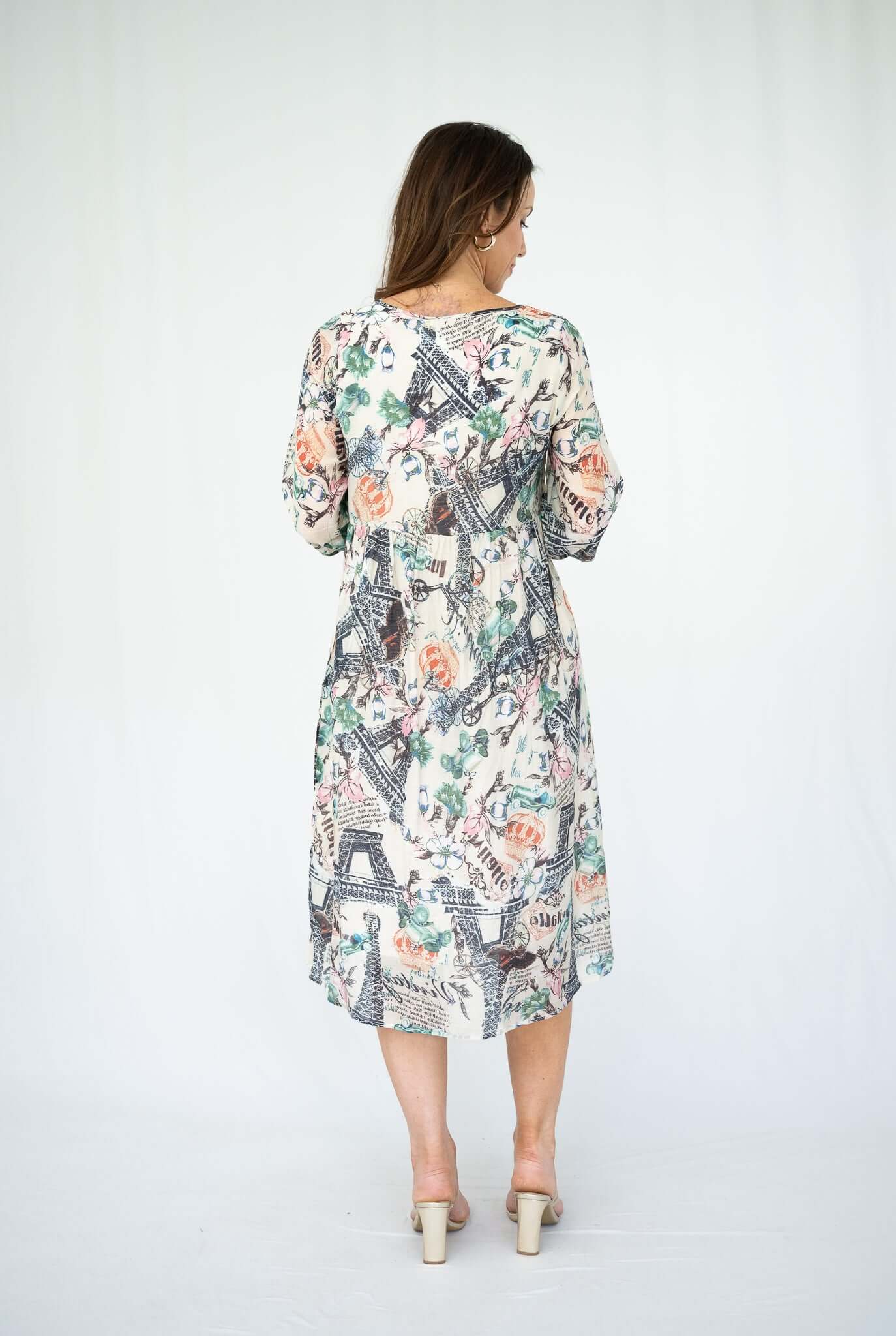 Model wearing the WT Suzy Eiffel Tower Dress Cream from the back, showcasing its charming Eiffel Tower print.