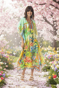 Model wearing the Georgia Kaftan surrounded by colorful flowers in a scenic garden.