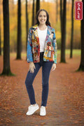 A woman wearing the Billie Jean Blazer in a colorful print, styled with jeans and a t-shirt, in an autumn forest setting.