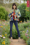 Model wearing Medellin Jacket 3333 in a floral garden, showcasing vibrant colors and quilted texture.