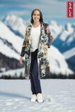 New york Long Coat on a woman standing in a snowy mountain landscape, showcasing vibrant prints.