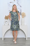 Model wearing Angelina Linen Panel Dress with floral pattern and pockets, standing in a stylish home setting.