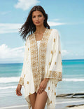 ATN Embroidered cape worn by a model at the beach, showcasing intricate artisan embroidery against a vibrant ocean backdrop.
