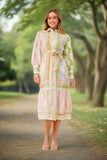Model wearing Ckm Carol Collared Dress with classic collar, balloon sleeves, and tie waist in a vibrant outdoor setting.