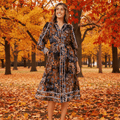 Model wearing the Oriana Midi Dress amidst vibrant autumn leaves, showcasing its elegant design and flattering silhouette.