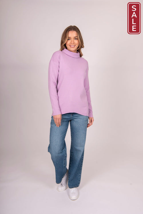 Model wearing the Bella Rollneck Lilac with blue jeans, showcasing its loose roll neck style.