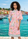 Dune Shirt Dress pink on model by the seaside, showcasing button-through front, tie waist, and scalloped edges.
