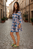 Rubyyaya Maple dress Navy on a model standing in a cobblestone street showcasing its playful style and tie waist.