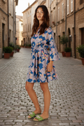 Rubyyaya Maple dress Navy on a model standing in a cobblestone street showcasing its playful style and tie waist.