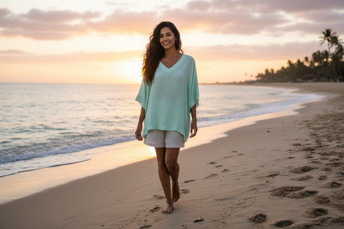Woman enjoying a sunset at the beach wearing a Barika V neck top in a soft, relaxed fit and light colors.