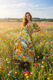 Beautiful woman in a vibrant floral field wearing the Guatemala V neck Bias Dress, showcasing elegance and style.