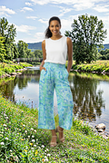 Model wearing Montevideo Aqua Pant by Orientique, styled with a casual tank top near a scenic lakeside.