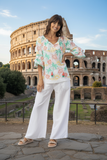 Escape Carol top worn by a model in front of the Colosseum, showcasing vibrant colors and tassel details.