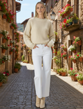 Model wearing Wanderer Jeans White on a sunny beach, showcasing a stylish hi-rise, wide leg design.