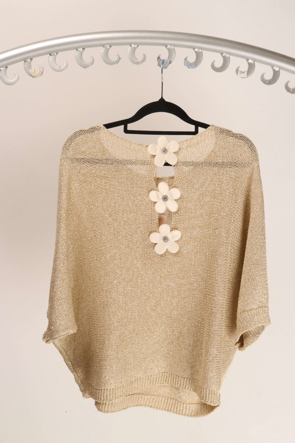 WL Daisy Back Top showcasing daisy-inspired back detail and premium fabric on a hanger.