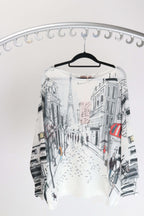 Rosa Jojo Paris street scene Knit displaying a Paris street scene design with a boat neck and bat wing sleeves.
