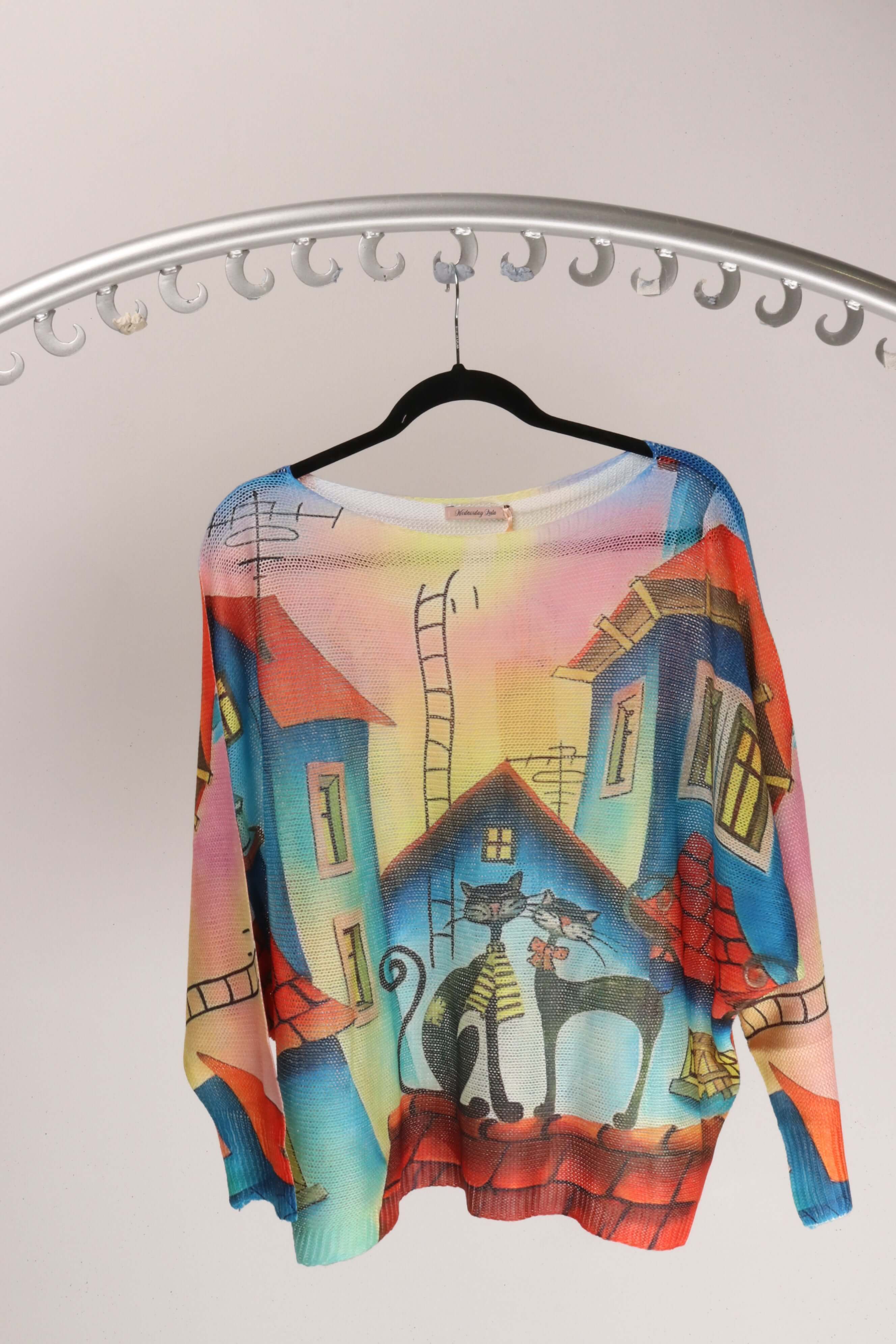 Two Cats Knitted top displayed on a hanger showcasing colorful design with playful cats and dreamy houses.