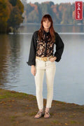 Model showcasing the Juelas Shirt Black by Rubyyaya, styled with white pants by a serene lake background.