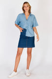 Model showcasing the Durango Skirt Dark with a chambray shirt and sneakers, featuring a stylish knee-length design.