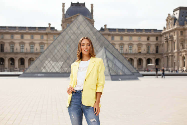 Model wearing Limoncello Linen Blazer in front of the Louvre Pyramid, showcasing a stylish summer look.