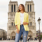 Model wearing Limoncello Linen Blazer in lemon yellow with chic jeans, set against a stunning urban backdrop.