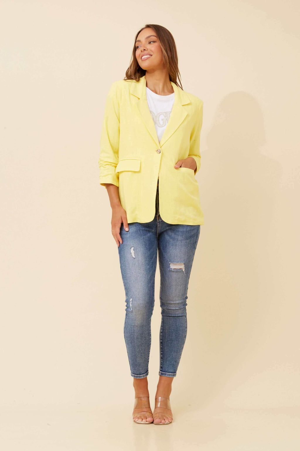 Model wearing the Limoncello Linen Blazer with jeans, showcasing vibrant lemon yellow style and elegant details.