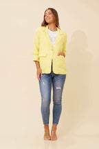 Model wearing the Limoncello Linen Blazer with jeans, showcasing vibrant lemon yellow style and elegant details.