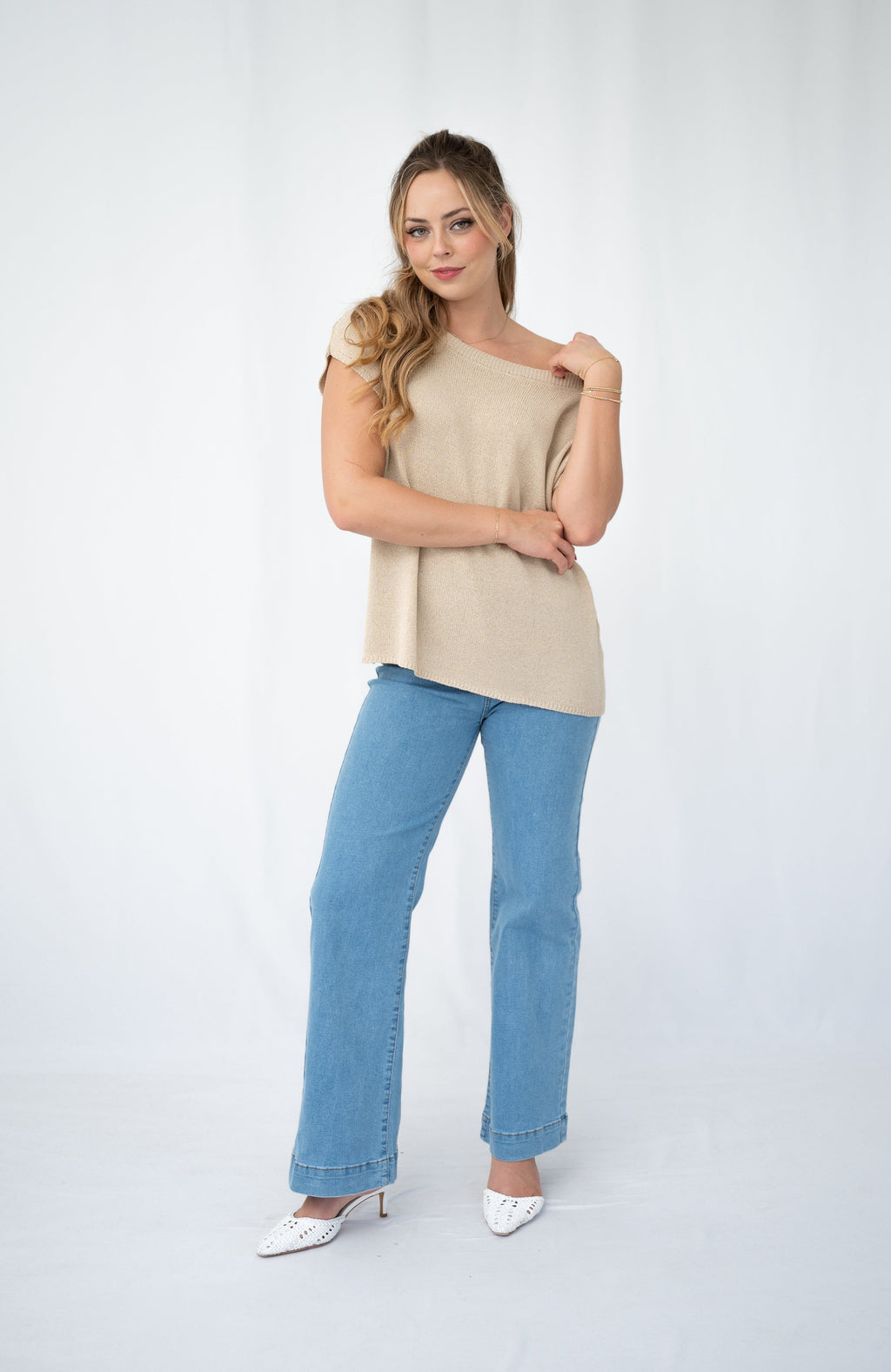 Woman wearing a casual Crepe yarn knit top with a scoop neckline and blue jeans, showcasing relaxed elegance.