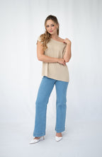 Woman wearing a casual Crepe yarn knit top with a scoop neckline and blue jeans, showcasing relaxed elegance.