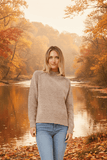 Woman wearing a Katya High neck jumper by a tranquil river in autumn, showcasing its stylish high neckline and cozy fit.