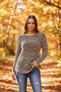 Model showcasing the Sunniva Multi Knit jumper in a scenic autumn setting with colorful foliage.