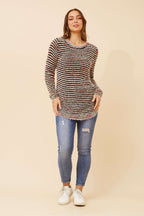 Sunniva Multi Knit jumper model wearing a multi-tonal design, paired with jeans for a stylish look.