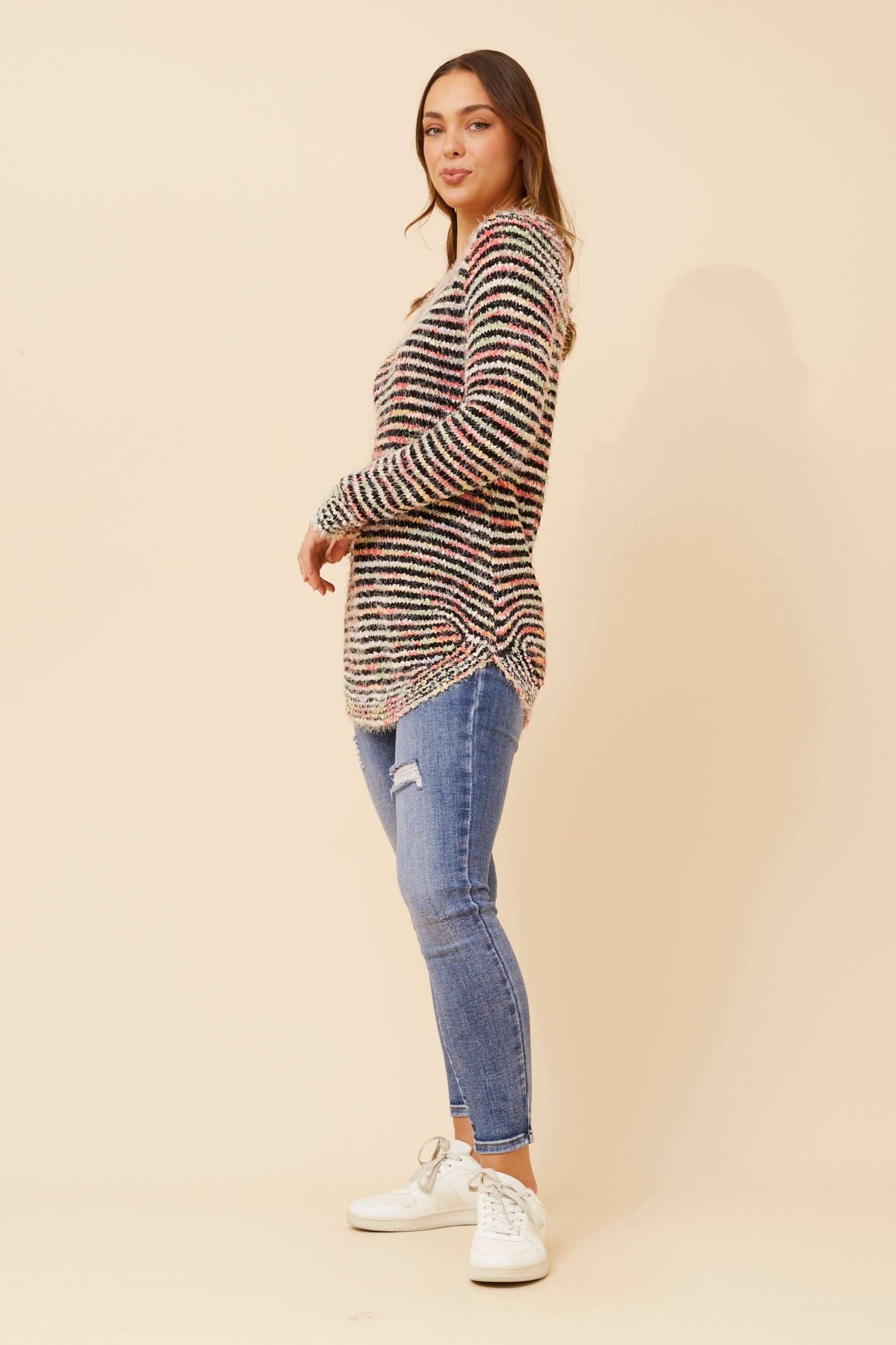 Stylish model wearing the Sunniva Multi Knit jumper with a scoop neckline, layered over jeans for a chic look.