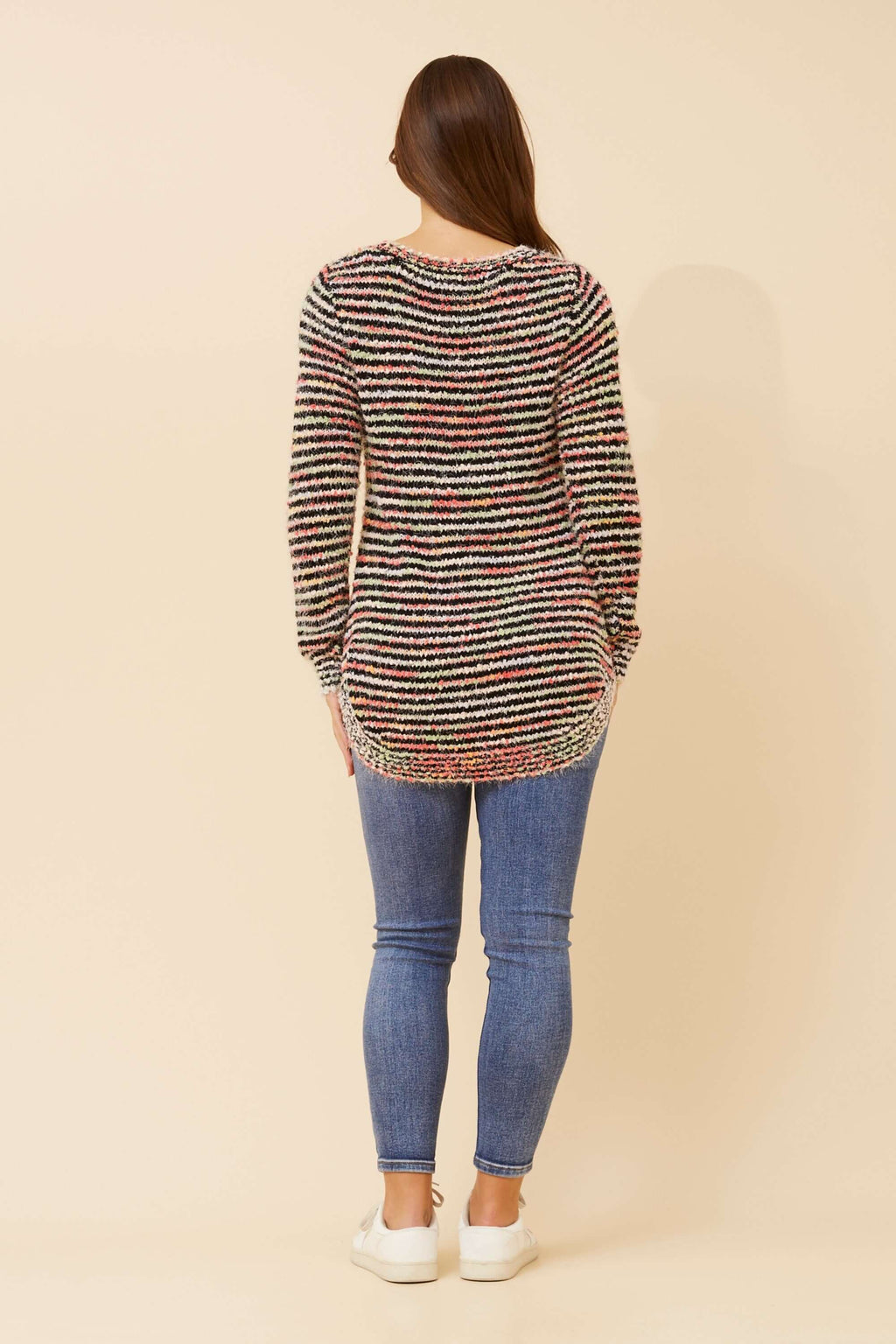 Woman wearing the Sunniva Multi Knit jumper, showcasing the back view with colorful striped design.