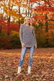 Model wearing the Sunniva Multi Knit jumper in a colorful fall scene with autumn leaves.